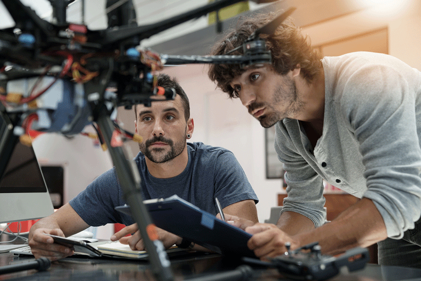 Two people working together on a drone